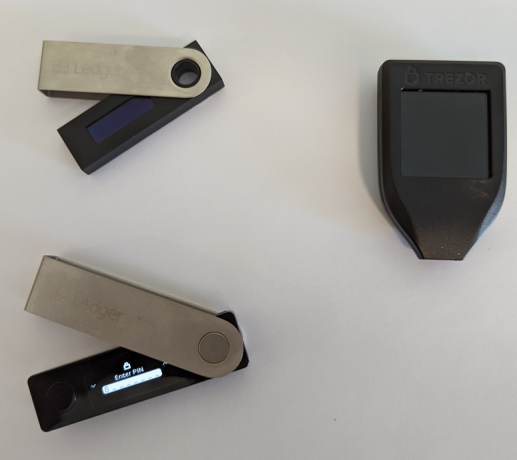 Ledger Nano S (viršuje kairėje), Ledger Nano X (kairėje apačioje) ir Trezor Model T (dešinėje)