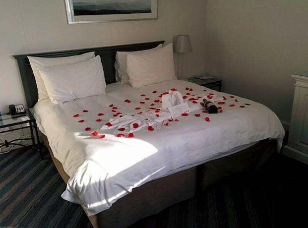 Ein „Flitterwochen“-Hinweis in unserer Reservierung im Radisson Blu Waterfront Hotel in Kapstadt, Südafrika, führte zu einem mit Rosenblättern bedeckten Bett und einer Flasche Champagner! Ähnliche Leckereien begrüßten uns auch in anderen Hotels.