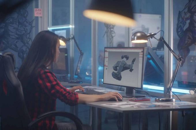 책상에 앉아 컴퓨터 화면에서 3d 애니메이션을 보고 있는 소녀