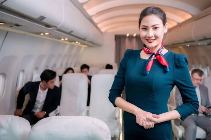 stjuardess, kes lennukis seistes kaamera jaoks naeratab